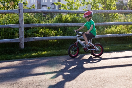 Child bicycling on the bike path in the parkの写真素材