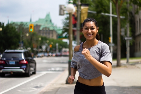 Fit young woman running on a busy city streetの写真素材