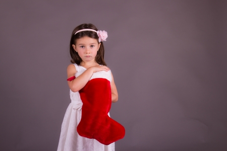 Sad little girl with Christmas stockingの写真素材