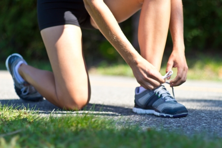 Woman tying her shoes before runningの写真素材
