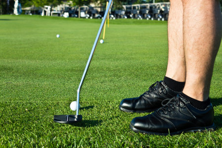 Golf player putting the ball