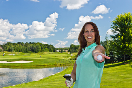 Woman with golf ball and club on the fairwayの写真素材