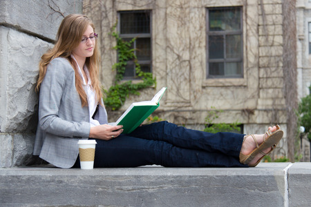 Pretty student quietly reading a bookの写真素材