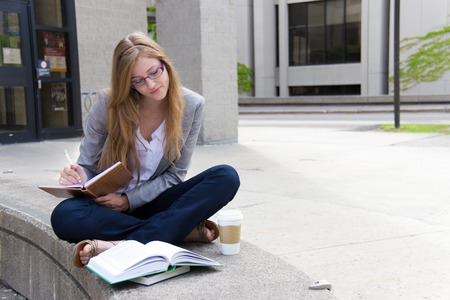 Studying on campus with books and notepadの写真素材