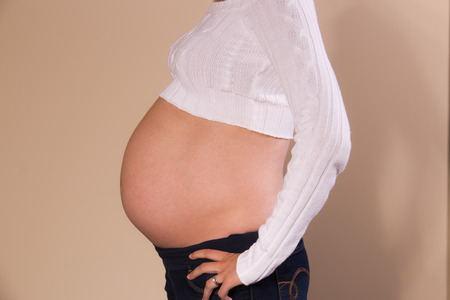 Side view of exposed belly of a pregnant girlの写真素材