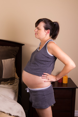 Expecting mother with back painの写真素材
