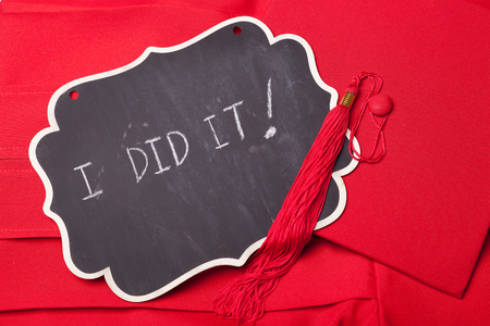 Little blackboard on a red graduation gownの写真素材