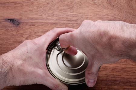 Two hands opening a can of tunaの写真素材