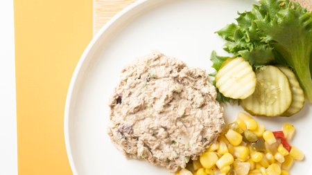 Tuna salad with sweet corn and cucumber on white plate.の写真素材