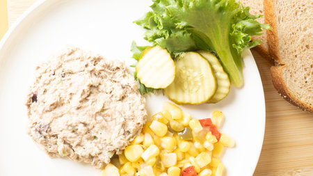 Tuna salad with corn and lettuce on a white plate.の写真素材
