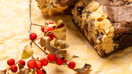 Chocolate chip cookies with berries and autumn leaves on craft paper backgroundの写真素材