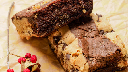 Chocolate cake with nuts and raisins on a baking paperの写真素材