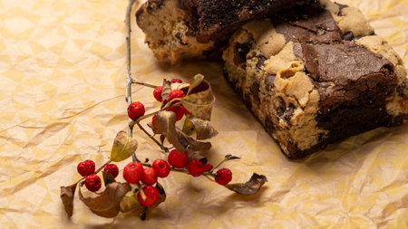 Chocolate cake with raisins and nuts on a paper backgroundの写真素材