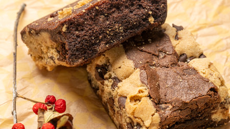 Chocolate cake with nuts and raisins on a baking paperの写真素材