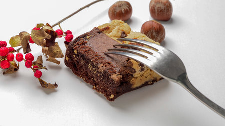 Chocolate cake with hazelnuts and red berries on a white backgroundの写真素材