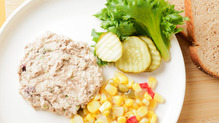 Tuna salad with sweet corn and cucumber on white plate.の写真素材