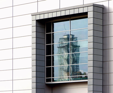 window with a reflection of the opposite tower