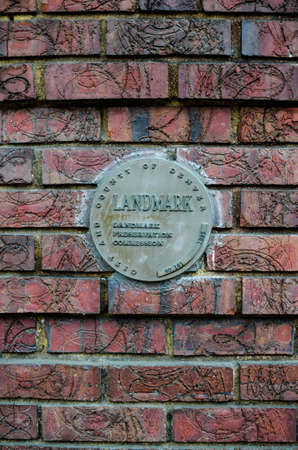 Landmark plaque embeded in brick wall on side of building.のeditorial素材