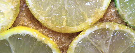 view on slices of limes and lemons mixed with cane sugar placed flat on the groundの写真素材