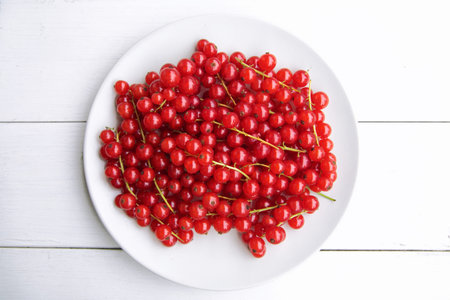 closeup of a bunch of delicate and fresh redcurrants with white background