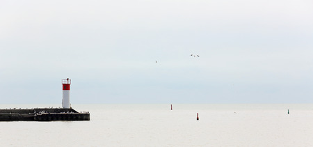 Pier with gulls jutting into a quiet Lake Erie on a grey dayの写真素材
