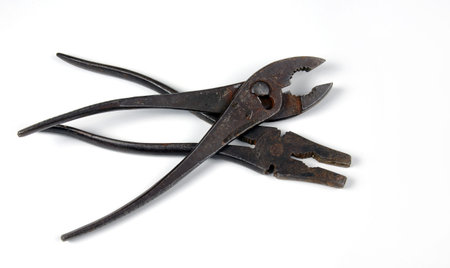 Two crossed vintage pliers on a white background