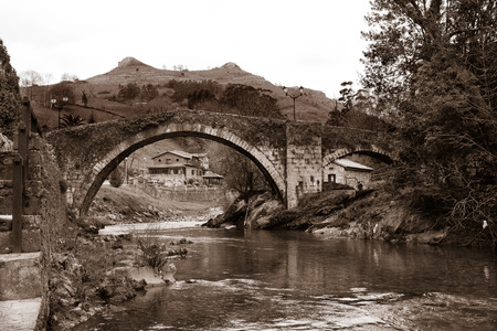 Lierganes medieval bridge and fish moumnto man. Spainの写真素材