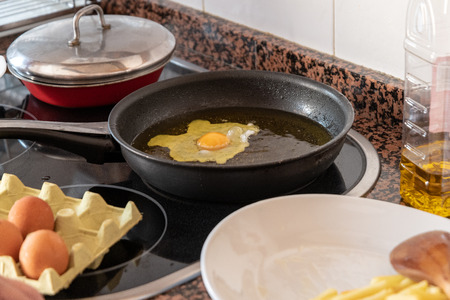 cook a cold egg with fries in olive oilの写真素材