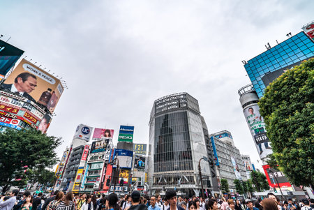 Tokyo, JP - June 21, 2018: Scenery of landmark business building and billboards in Shibuya City, with rush crowd of people and tourists in street.のeditorial素材