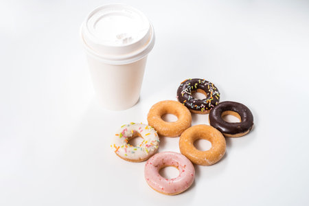 Donuts and drink decorated icing and sprinkles on white background top view copy space patternの写真素材