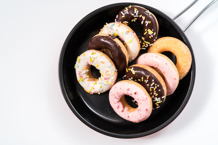 Donuts and drink and iron frying panon white background top view copy space pattern