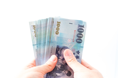 A hand holding a 1000 New Taiwan Dollar bill.の写真素材