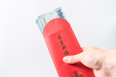 Man's hand holding with Chinese red envelope (red packet). Chinese new year concept.の写真素材