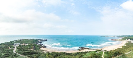 Aerial view of sandy beach with tourists swimming in beautiful clear sea waterの写真素材