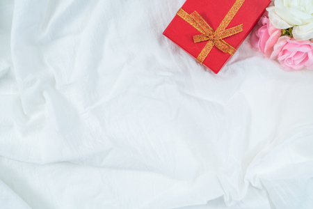 Red cardboard box for gifts and flower, isolated, white fabric texture backgroundの写真素材