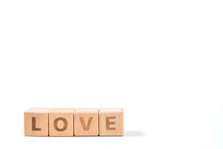 word LOVE on wood cube dices on white background.