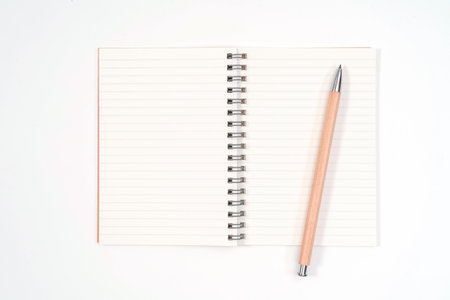 Top view blank Wood color diary and pencil on white desk
