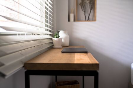 Workplace near the window with laptop and computer. Copy spaceの写真素材