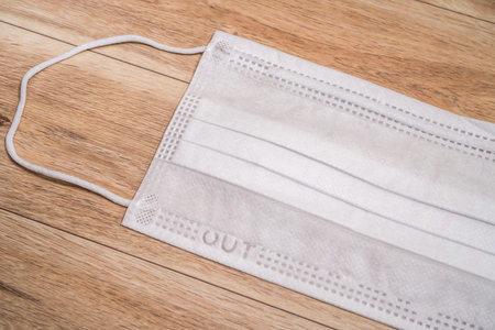 Protective medical mask on wood table background.