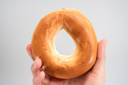 Ring bread (bagel) in hand isolated on white