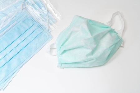 Surgical mask with rubber ear straps. Typical 3-ply surgical mask to cover the mouth and nose. Procedure mask from bacteria. Protection concept.の写真素材