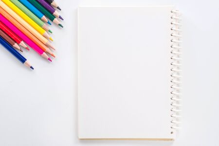 notepad with color pencil on white table view from aboveの写真素材