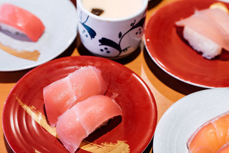 Sushi and Sashimi. Dishes of Sushi and Sashimi rolling on conveyer belt.