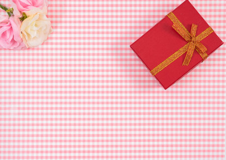 gift box with red isolated on Plaid background. Holiday decoration for Mother's Day or Women's Day.の写真素材
