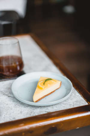lemon Cheesecake with iced coffee on tableの写真素材