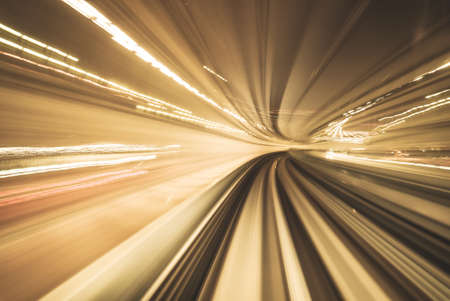 Motion blurred of train moving inside tunnel with daylight in tokyo, Japan. yollow color background conceptの写真素材