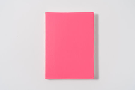 Pink notebook on white desk. Business minimal concept for women. Flat lay, top view, copy spaceの写真素材