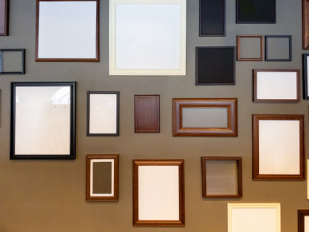 A Collection of Memories: Empty Picture Frames of Different Colors and Textures on a Gray Wallの写真素材