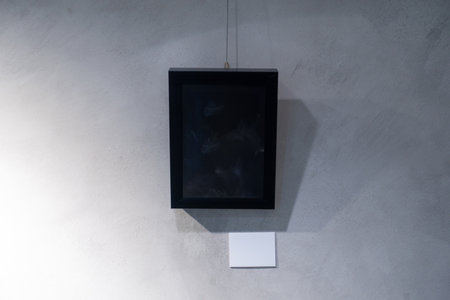 A Moment in Time: A Black Picture Frame Hanging on a Gray Concrete Wallの写真素材