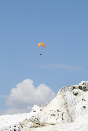 Paragliding over over mountain in cotton castle pamukkale turkeyの写真素材